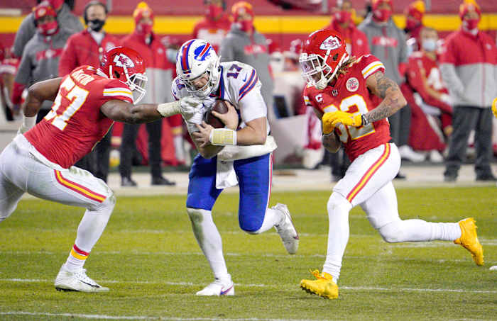 Jan 24, 2021; Kansas City, Missouri, USA; Buffalo Bills quarterback Josh Allen (17) scrambles as Kansas City Chiefs defensive end Alex Okafor (57) and strong safety Tyrann Mathieu (32) attempt the sack in the AFC Championship Game at Arrowhead Stadium.